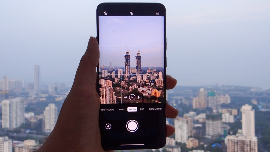 A hand holding a smartphone with Mumbai city skyline in the background, representing India smartphone market