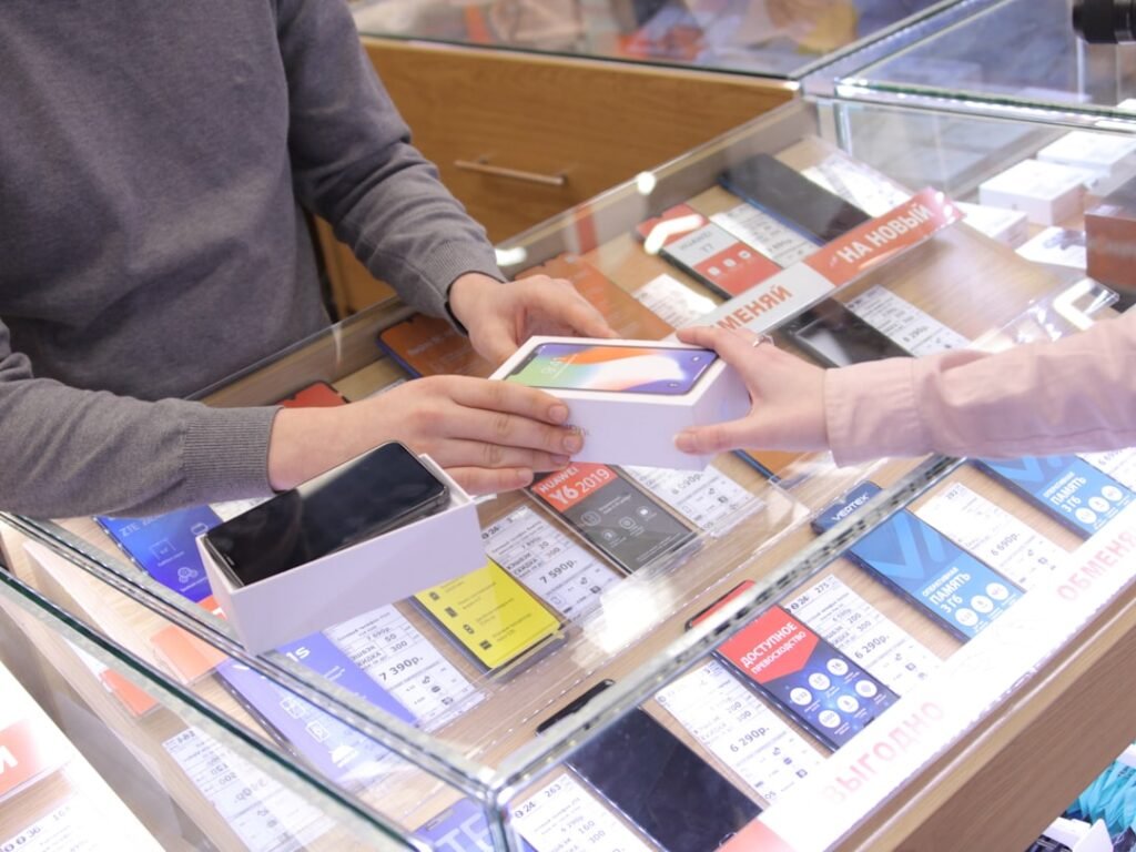 Customer buying a smartphone at a phone store, illustrating the decision to buy now or wait
